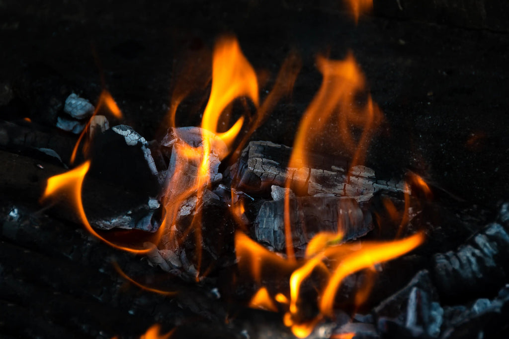 Brennende Holzkohle mit orangenen Flammen.